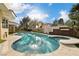 Beautiful backyard pool and spa, with custom accents, surrounded by lush landscaping at 42 Sawgrass Ct, Las Vegas, NV 89113