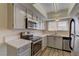 Updated kitchen features stainless steel appliances, white cabinets, modern countertops and laminate floors at 4666 Monterey Cir # 4, Las Vegas, NV 89169