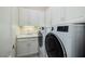 Laundry room features modern washer and dryer with white cabinets and sink at 52 Via Paradiso St, Henderson, NV 89011