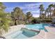 Beautiful pool and hot tub with mature landscaping and dolphin statue under a sunny sky at 52 Via Paradiso St, Henderson, NV 89011