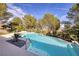 Inviting backyard pool surrounded by lush landscaping, a waterfall feature, and mountain views at 52 Via Paradiso St, Henderson, NV 89011