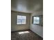 Well-lit bedroom with two windows and neutral colored walls and carpeting at 5273 Wave Dancer Ln, Las Vegas, NV 89118