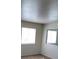 Bright bedroom with two windows and neutral colored walls and carpeting at 5273 Wave Dancer Ln, Las Vegas, NV 89118