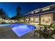 Nighttime view of the backyard pool, patio, outdoor seating, and well-lit landscaping for evening enjoyment at 5573 San Florentine Ave, Las Vegas, NV 89141