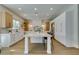 Bright kitchen with stainless steel appliances, a large island with seating, and wood and white cabinets at 5573 San Florentine Ave, Las Vegas, NV 89141