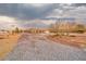 Ranch style house on a large lot with gravel driveway and landscaping, set against a dramatic sky at 620 W Leffner Dr, Pahrump, NV 89060
