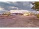Wide shot showcasing a home with a long gravel driveway and landscaping, offering a sense of privacy at 620 W Leffner Dr, Pahrump, NV 89060
