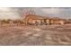 Side view of a home with gravel landscaping and wrought iron fencing, offering privacy and space at 620 W Leffner Dr, Pahrump, NV 89060