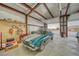 Open garage space with a car, a workbench area, and storage racks, perfect for car enthusiasts or hobbyists at 620 W Leffner Dr, Pahrump, NV 89060