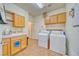 Functional laundry room with cabinets, washer, dryer and utility sink at 620 W Leffner Dr, Pahrump, NV 89060