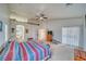 Spacious primary bedroom with plush carpeting, a ceiling fan, and a sliding glass door to the yard at 620 W Leffner Dr, Pahrump, NV 89060