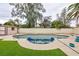 A beautiful backyard features a private pool, lush artificial grass, and tropical landscaping at 6309 Fairbanks Rd, Las Vegas, NV 89103
