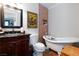Bathroom featuring a claw foot tub, dark vanity, and accent tile on one wall at 6309 Fairbanks Rd, Las Vegas, NV 89103