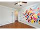 Bedroom featuring hardwood floors, ceiling fan, and colorful geometric wall art at 6309 Fairbanks Rd, Las Vegas, NV 89103