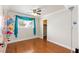 Bright bedroom with a colorful accent wall, ceiling fan and hardwood floors at 6309 Fairbanks Rd, Las Vegas, NV 89103