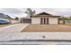Exterior shot of a single-story home with desert landscaping, a two-car garage, and a long driveway at 6309 Fairbanks Rd, Las Vegas, NV 89103
