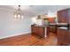 Open-concept kitchen and dining area with hardwood floors, stainless steel appliances, and a chandelier at 6309 Fairbanks Rd, Las Vegas, NV 89103