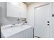 Clean and functional laundry area with a washer, dryer, and convenient storage cabinets at 6309 Fairbanks Rd, Las Vegas, NV 89103