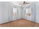 Bright bedroom with neutral carpeting, a ceiling fan, and two windows with coverings at 693 Calamus Palm Pl, Henderson, NV 89011