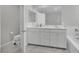 Bright bathroom featuring double vanity, modern fixtures and white cabinets and drawers at 6945 Trevelez St, Las Vegas, NV 89149