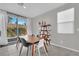 Bright dining area with sliding glass doors to the backyard, next to a window and gray walls at 6945 Trevelez St, Las Vegas, NV 89149