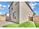 Two-story home exterior showing a landscaped yard with brick-paved patio, wall, and lush turf at 6945 Trevelez St, Las Vegas, NV 89149