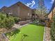 Backyard with a putting green surrounded by lush landscaping and greenery, offering a private outdoor retreat at 72 Reverie Heights Ave, Henderson, NV 89011