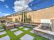 Backyard with stone pavers and faux grass features a water feature with lounge seating at 72 Reverie Heights Ave, Henderson, NV 89011