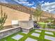 Tranquil backyard features artificial turf with stepping stones, a water feature, and landscaped surroundings at 72 Reverie Heights Ave, Henderson, NV 89011