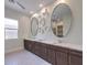 Modern bathroom with double sinks, dark wood cabinets, and elegant decorative accents at 72 Reverie Heights Ave, Henderson, NV 89011