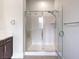 Modern bathroom with a glass door shower, neutral walls, and dark cabinets at 72 Reverie Heights Ave, Henderson, NV 89011