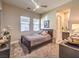 Cozy bedroom with a ceiling fan, carpet, windows and access to a bathroom at 72 Reverie Heights Ave, Henderson, NV 89011