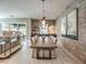 Open-concept dining room with a long wooden table, unique light fixtures, and a textured accent wall at 72 Reverie Heights Ave, Henderson, NV 89011