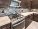 Close-up of a modern oven and stovetop with stainless steel appliances and marble countertops at 72 Reverie Heights Ave, Henderson, NV 89011