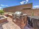 Outdoor kitchen with stainless steel grill and brick surround offers an exceptional backyard entertaining area at 72 Reverie Heights Ave, Henderson, NV 89011