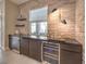 Stylish wet bar featuring stacked stone backsplash, floating shelves, and dual wine refrigerators at 72 Reverie Heights Ave, Henderson, NV 89011