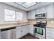 Kitchen with stainless steel appliances, light countertops, and gray cabinets at 7445 Shangri La Ave, Las Vegas, NV 89147