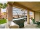 Covered patio area with BBQ island and outdoor dining space overlooking the pool and lush landscaping at 748 Fast Green Way, Las Vegas, NV 89148
