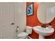 Stylish half bathroom featuring a pedestal sink and vibrant red accent wall at 748 Fast Green Way, Las Vegas, NV 89148