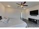 Comfortable bedroom with a ceiling fan, a large TV, and wood-look floors that enhance the living space at 748 Fast Green Way, Las Vegas, NV 89148