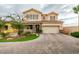 Charming two-story home featuring a well-manicured lawn, two-car garage and beautiful stone accents at 748 Fast Green Way, Las Vegas, NV 89148