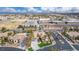 Gorgeous aerial shot of a desert home showcasing a landscaped front yard with palm trees, and a school nearby at 7816 Sandy Eagle Ct, Las Vegas, NV 89129