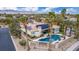 A serene backyard with a beautiful pool, lush landscaping, and a private sign for the neighborhood at 7816 Sandy Eagle Ct, Las Vegas, NV 89129