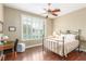 This bedroom has a ceiling fan, white window shutters, and hardwood flooring at 7816 Sandy Eagle Ct, Las Vegas, NV 89129