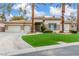 Inviting single-story home with a three car garage, lush landscaping, and long paved driveway at 7816 Sandy Eagle Ct, Las Vegas, NV 89129