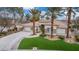 Beautiful single-story home with well-manicured lawn and mature trees on a sunny day at 7816 Sandy Eagle Ct, Las Vegas, NV 89129