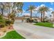 Beautiful single-story home featuring a three car garage, lush landscaping, and large paved driveway at 7816 Sandy Eagle Ct, Las Vegas, NV 89129