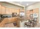 Bright kitchen with wood cabinets, granite counters, island with seating and stainless-steel appliances at 7816 Sandy Eagle Ct, Las Vegas, NV 89129