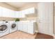 This laundry room has a washer, a dryer, and white cabinets at 7816 Sandy Eagle Ct, Las Vegas, NV 89129