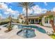 This backyard has a pool, spa, covered patio, and tropical landscaping at 7816 Sandy Eagle Ct, Las Vegas, NV 89129